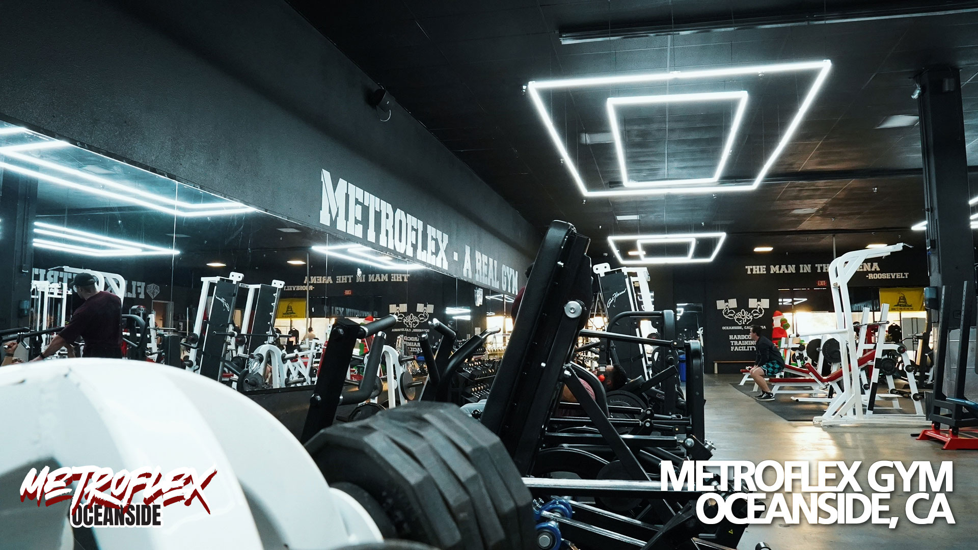 A stack of weight plates and machines on the gym floor.